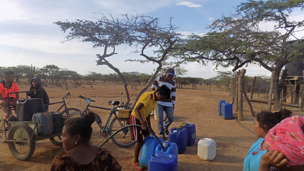 Pobladores de veredas vecinas a la ranchería Kasumana vienen y van llevando el agua para sus alimentos. La crisis hídrica de La Guajira los obliga a sobrevivir con muy poco líquido. Foto: María Teresa Arboleda Grajales.